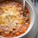 Bowl of Italian soup with a spoon inside.