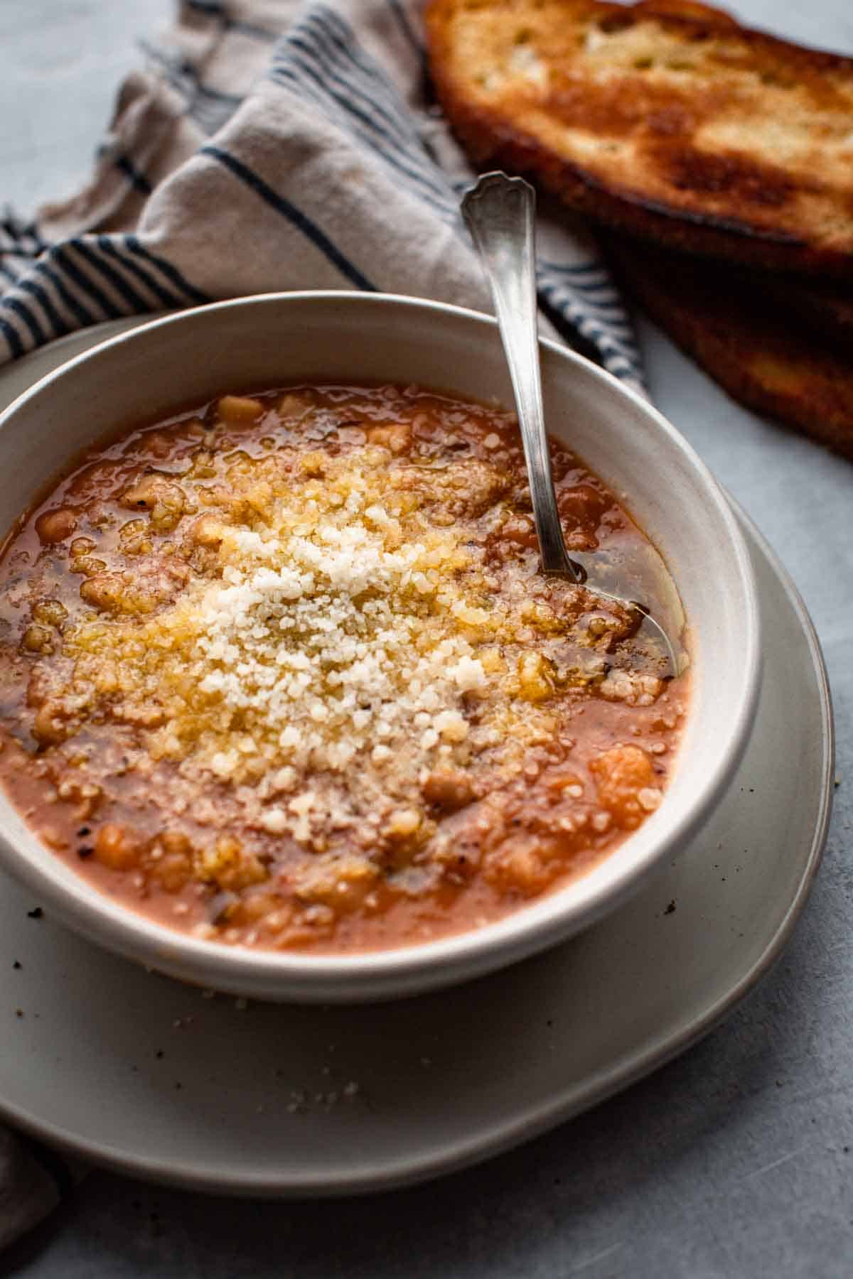 A large bowl of pasta fagioli topped with cheese.