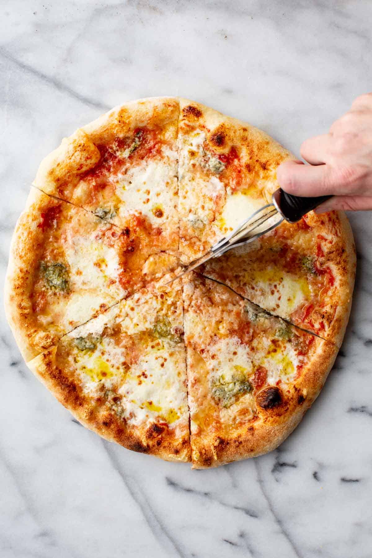Cutting Quattro Formaggi into slices for serving.