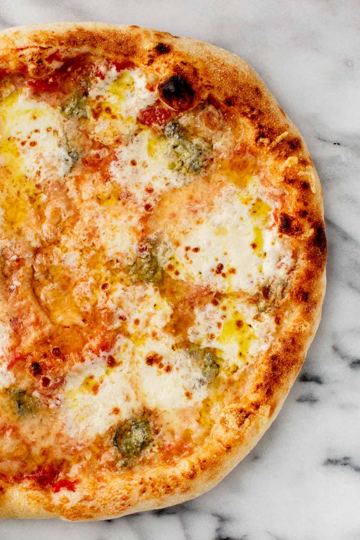 Close up of a perfectly charred quattro formaggi pizza.
