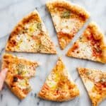 Four cheese pizza cut into slices.