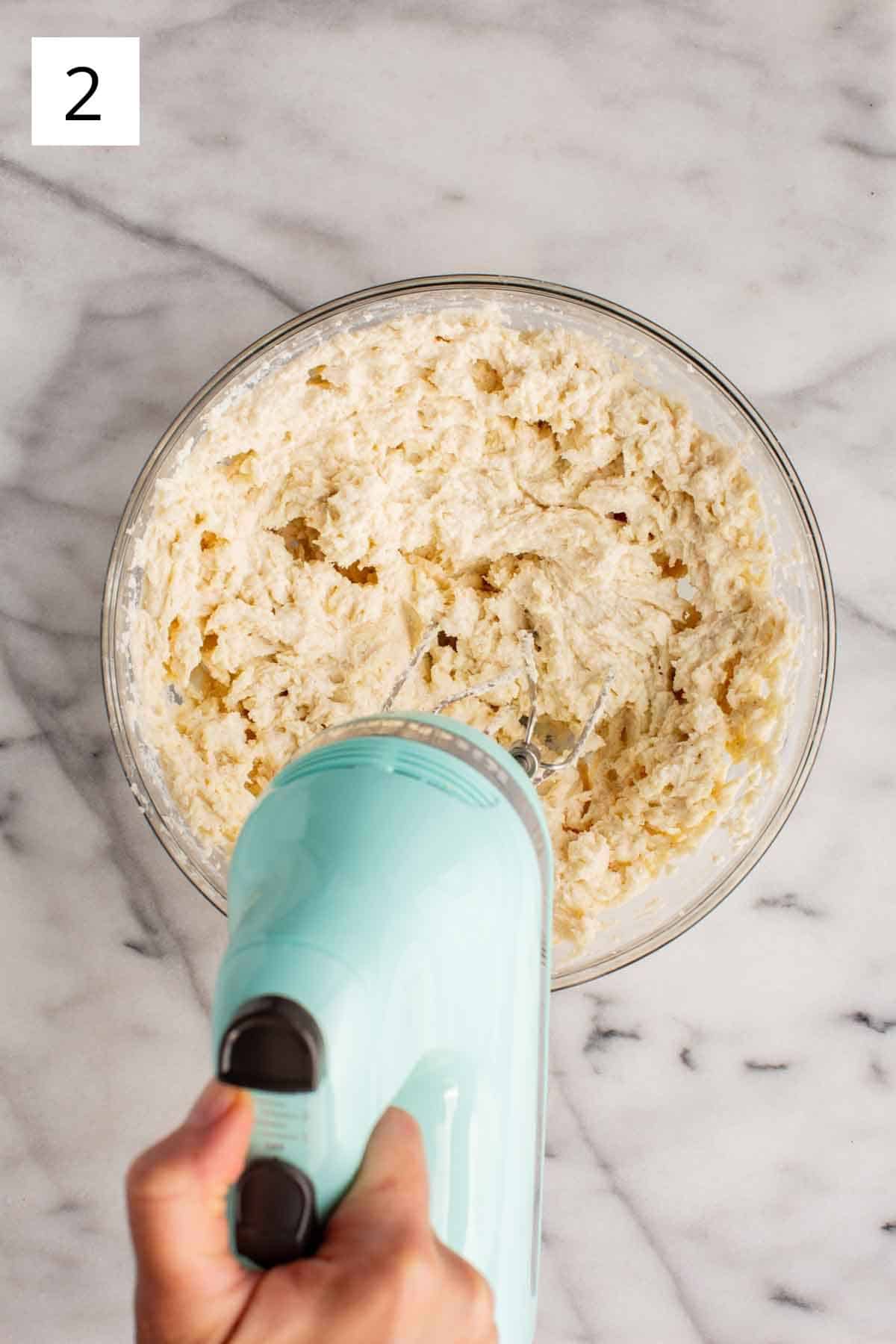 A mixer whipping ricotta filling for cannoli.