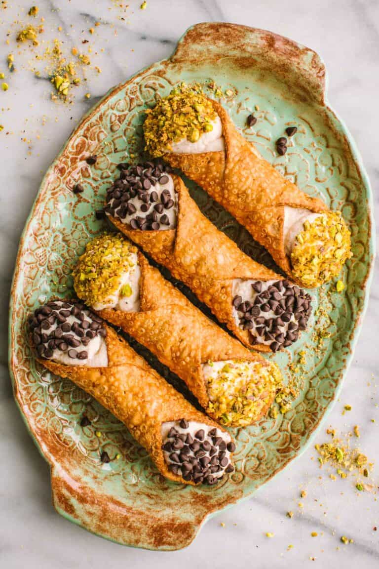 A light green tray of ricotta stuffed cannoli.