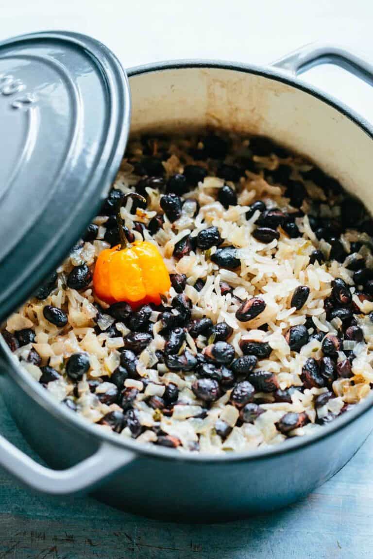 A freshly cooked pot of Caribbean rice and black beans with a scotch bonnet pepper on top.