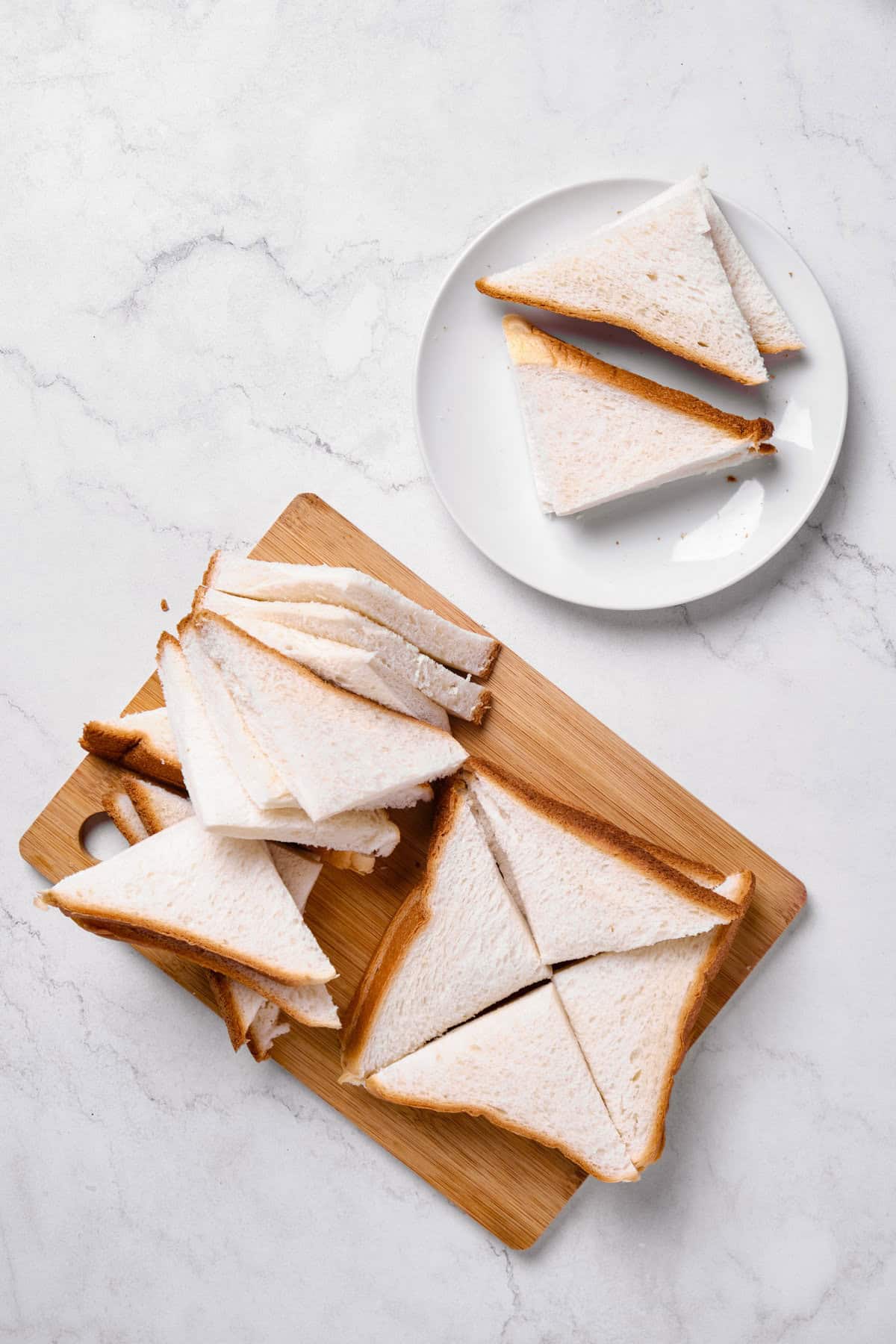 Sliced bread in triangles for cinnamon toast cookies.
