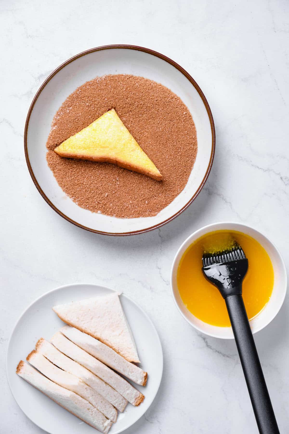 Dipping buttered bread in cinnamon sugar.
