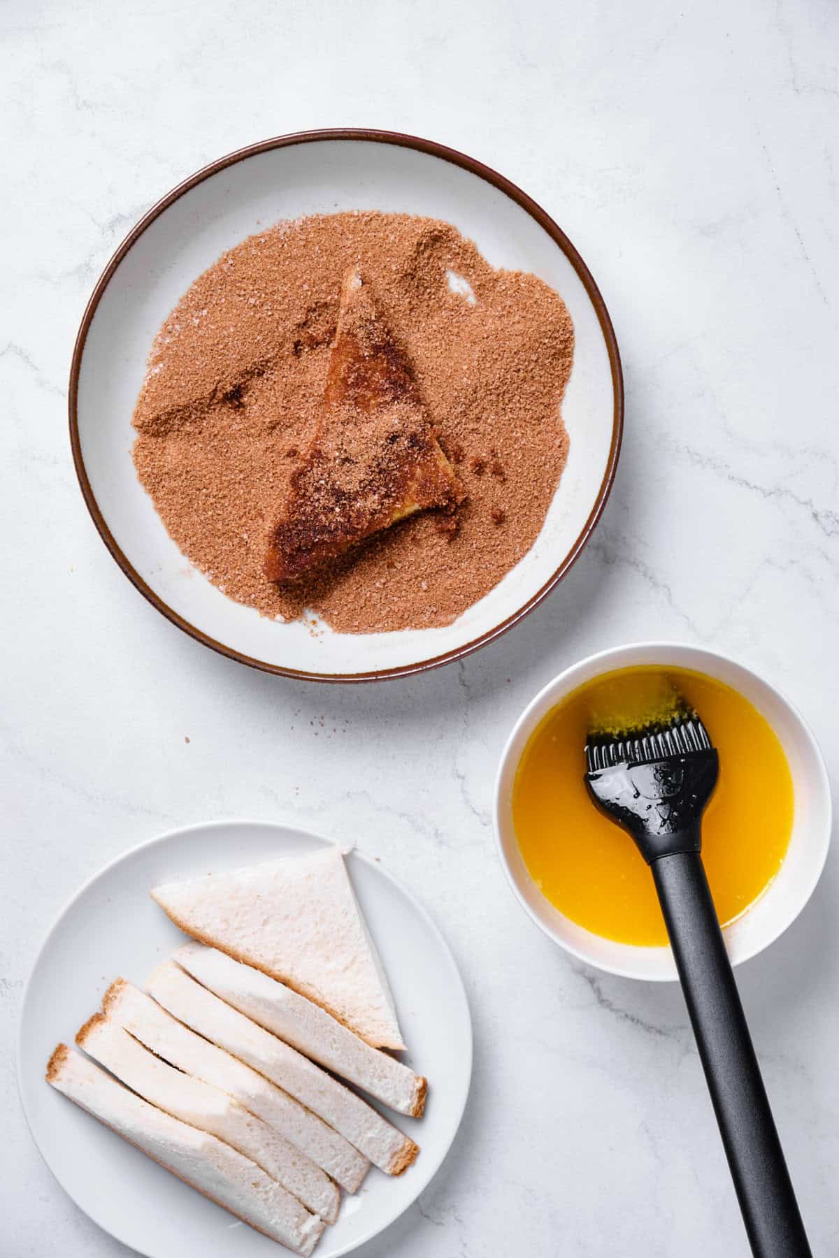 Rolling pieces of buttery bread in cinnamon sugar to make cookies.