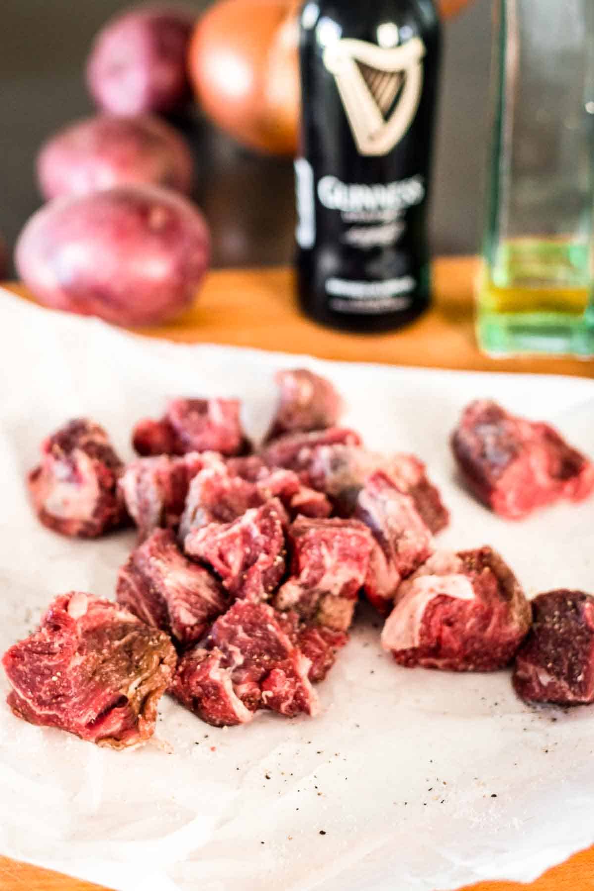 Fresh, raw beef stew meat cubes on butcher paper.