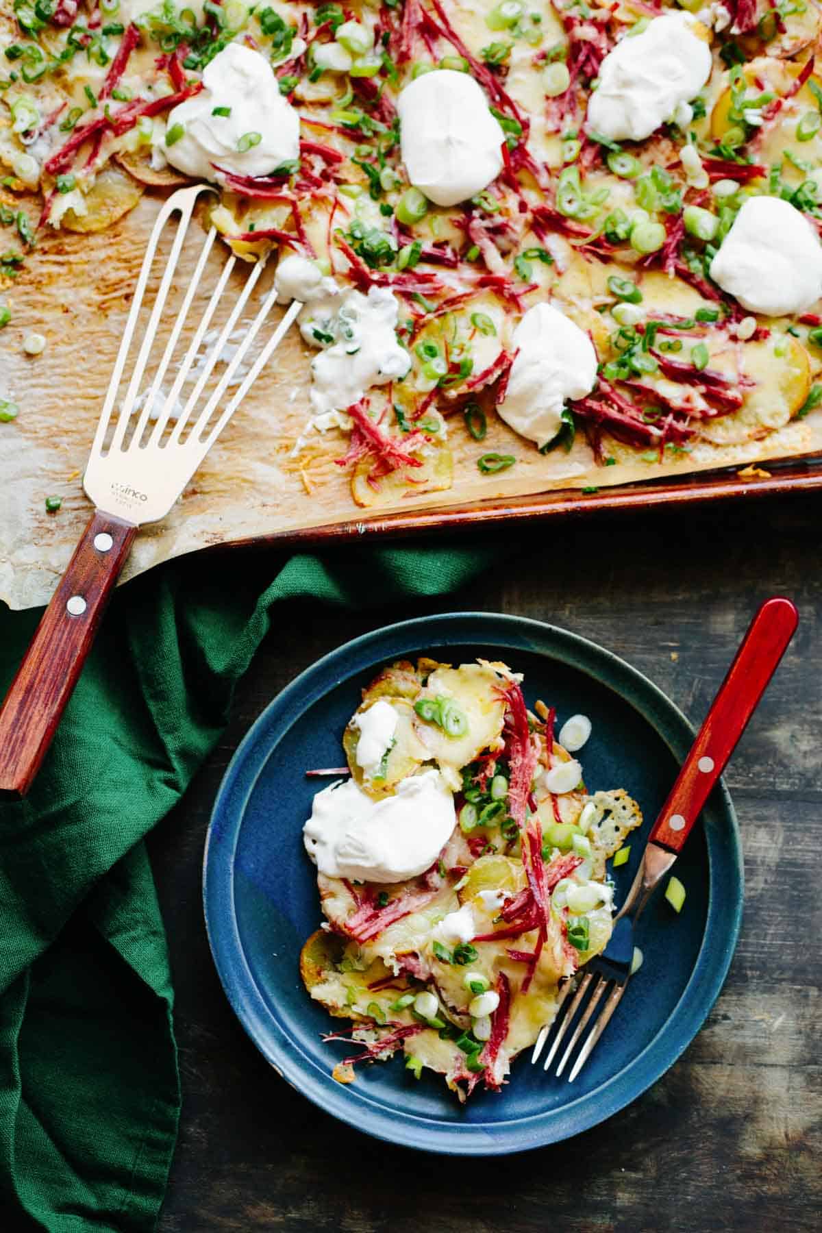 Dinner plate of Irish nachos next to a baking sheet.