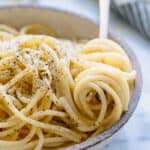 Close up of a fork that has twirled up some spaghetti cacio e pepe.