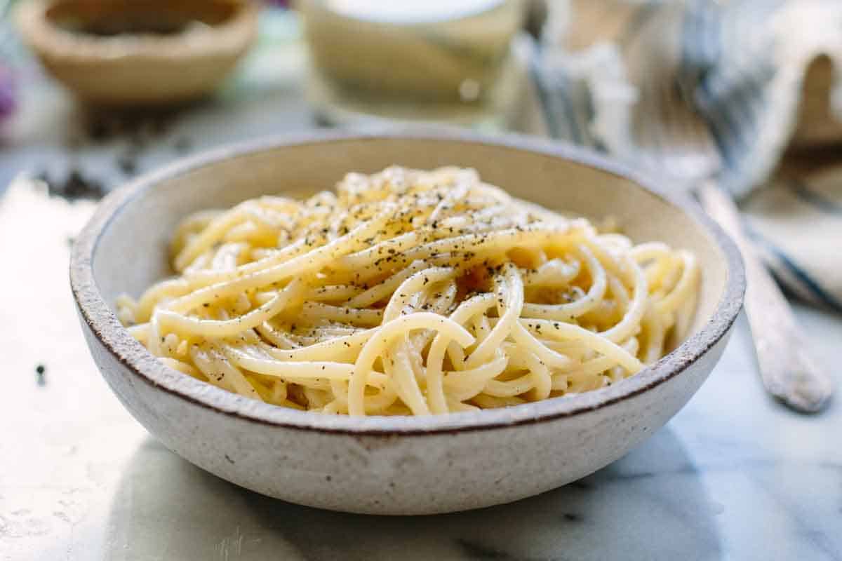 Stoneware bowl filled with cacio e pepe style spaghetti.