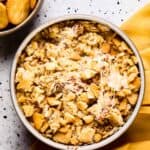 A baked dish of warm cheesy bacon dip with ritz crackers.