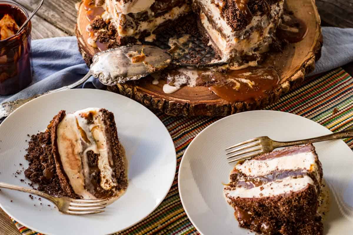 Slices of ice cream cake on plates with the cake in the background.