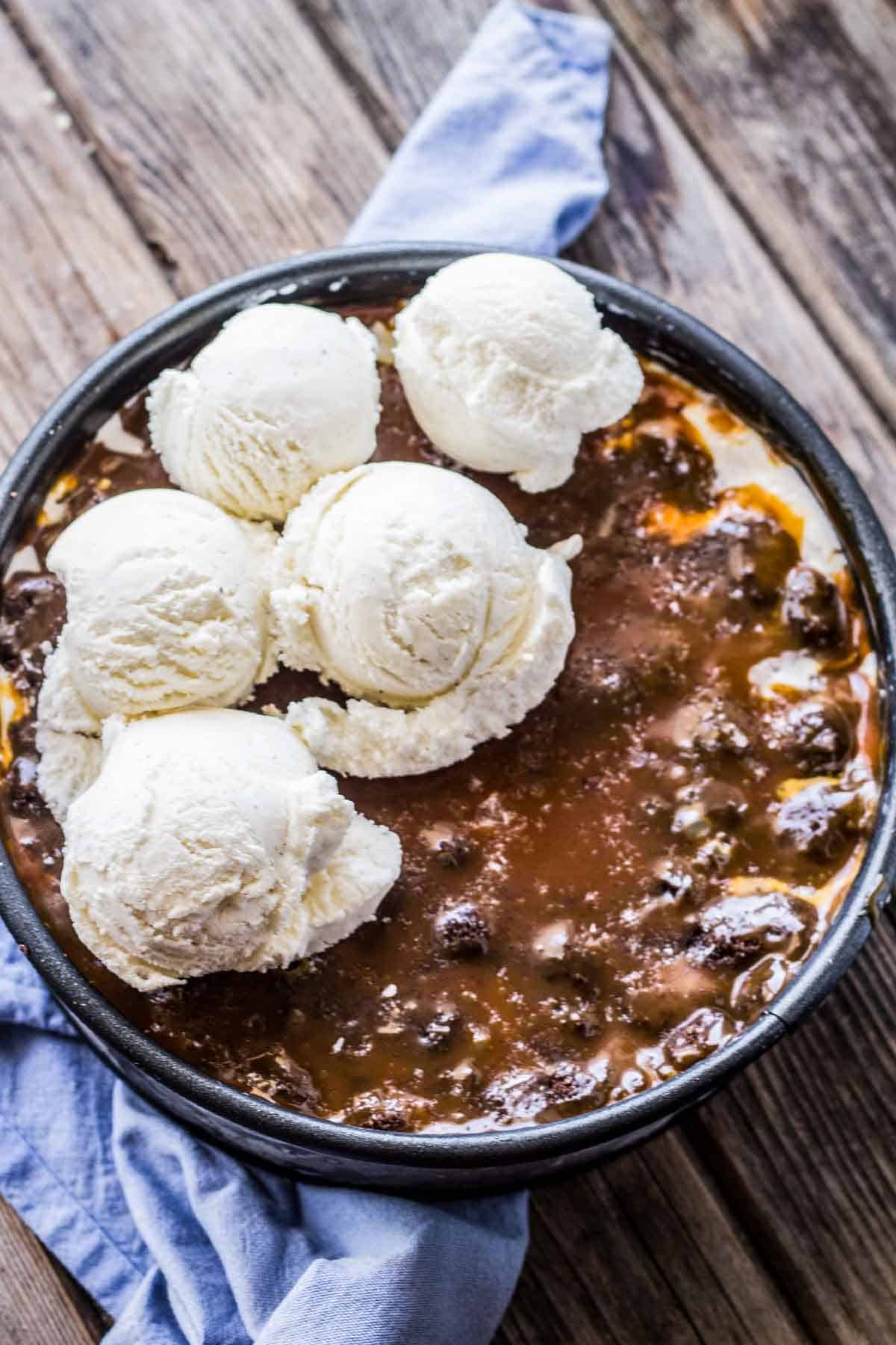 Scoops of ice cream in about to be spread in a layered ice cream cake.