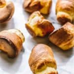 Freshly baked popovers splayed out on a marble board.