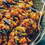 Eggplant caponata in a gray serving bowl with a spoon.