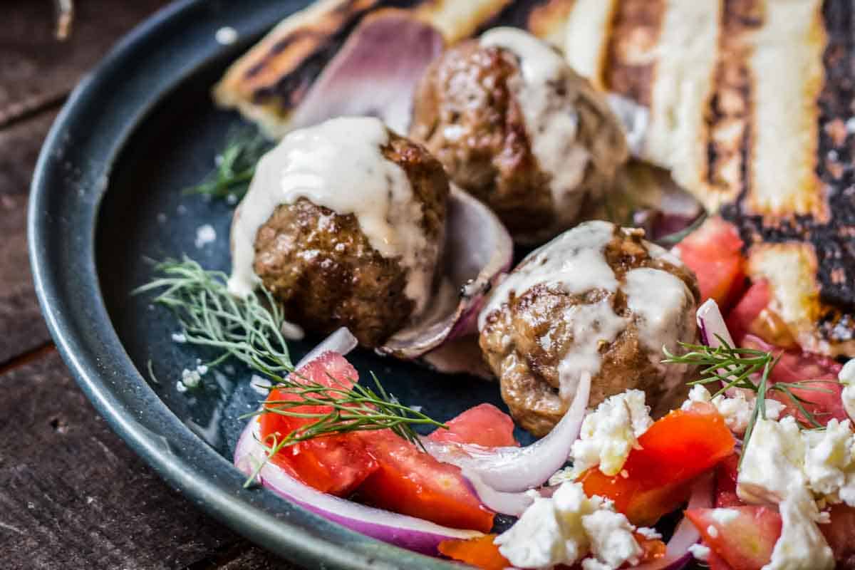 Grilled lamb meatballs and red onion drizzled with tahini sauce.