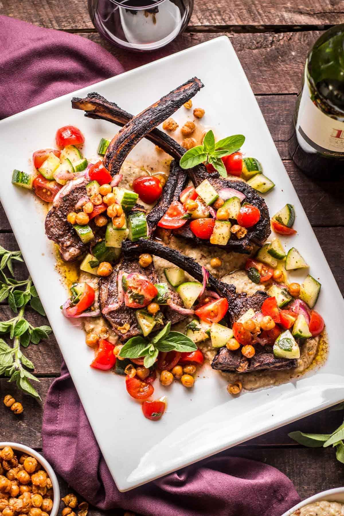 Grilled marinated Lamb Chops with vegetables and chick peas on a platter.