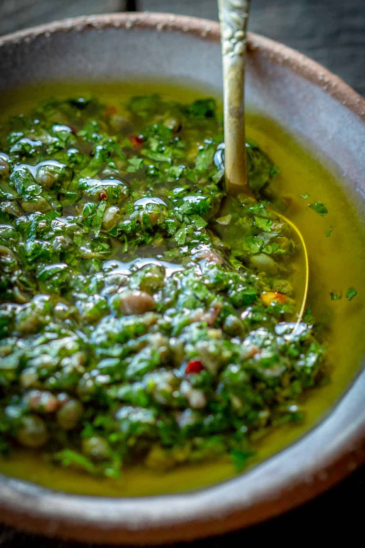 A dish of Italian salsa verde with vibrant green olive oil.