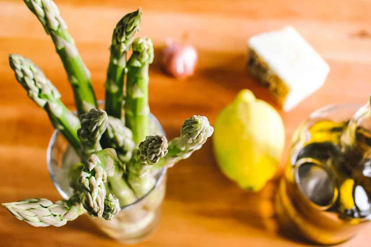 Ingredients for shaved asparagus salad on a wood board.