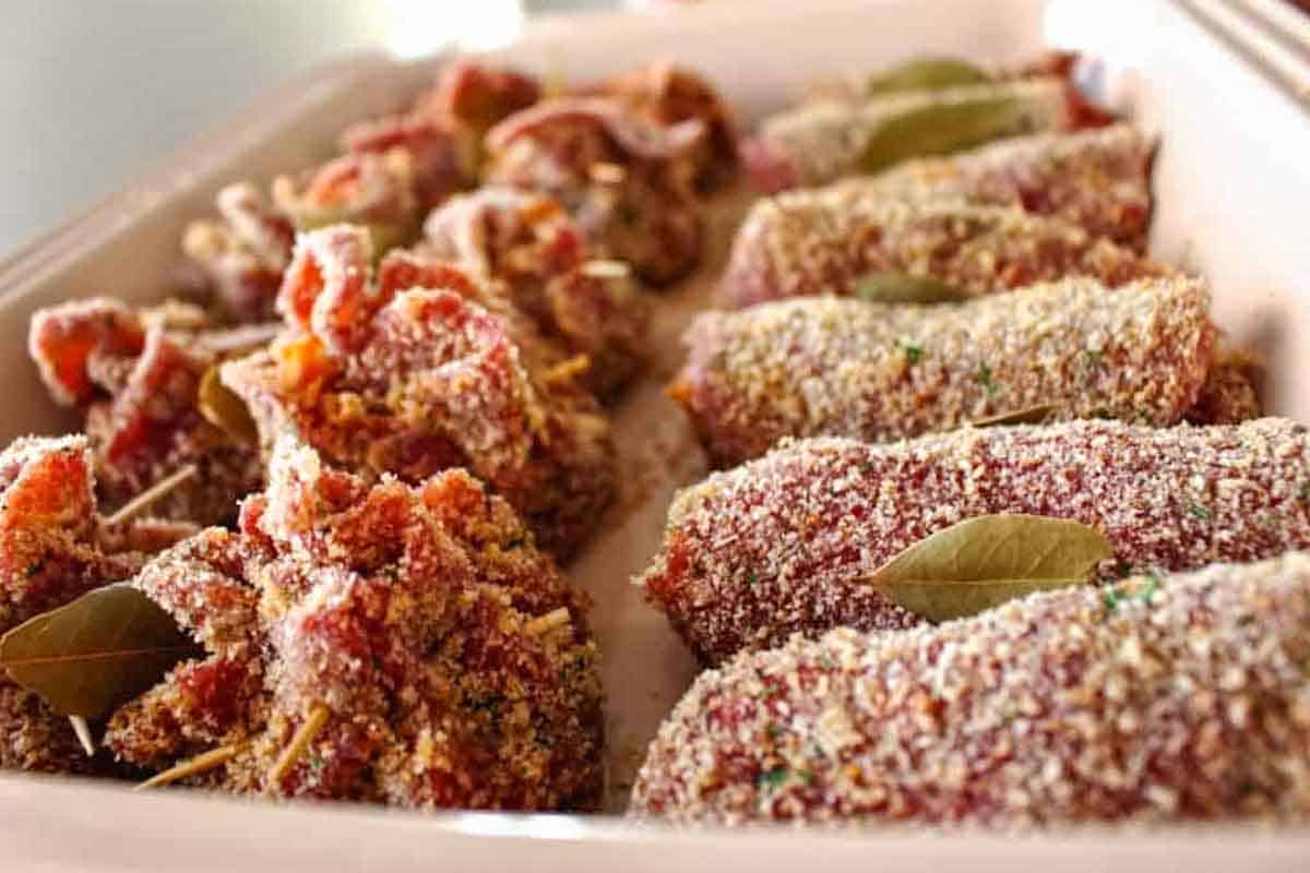 A tray of unbaked, assembled spiedini ready for the oven.