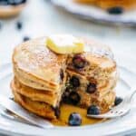 A stack of pancakes with a piece taken out so the insides are visible.