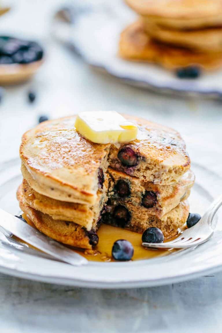 A stack of pancakes with a piece taken out so the insides are visible.