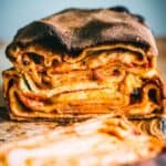A loaf of local Sicilian bread from Ragusa cut in half to reveal the layers of sauce and cheese.