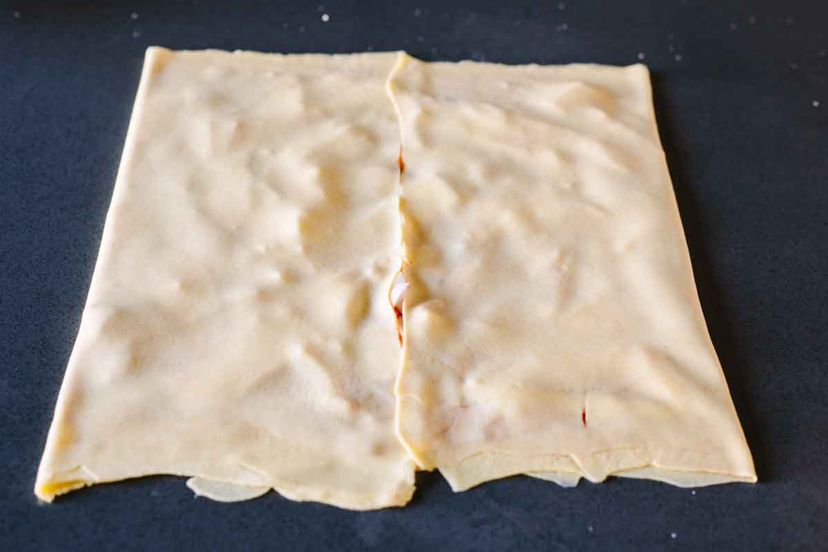 Thinly rolled out dough being folded over onto itself.