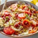A platter of Sicilian blood orange and fennel salad with serving utensils.
