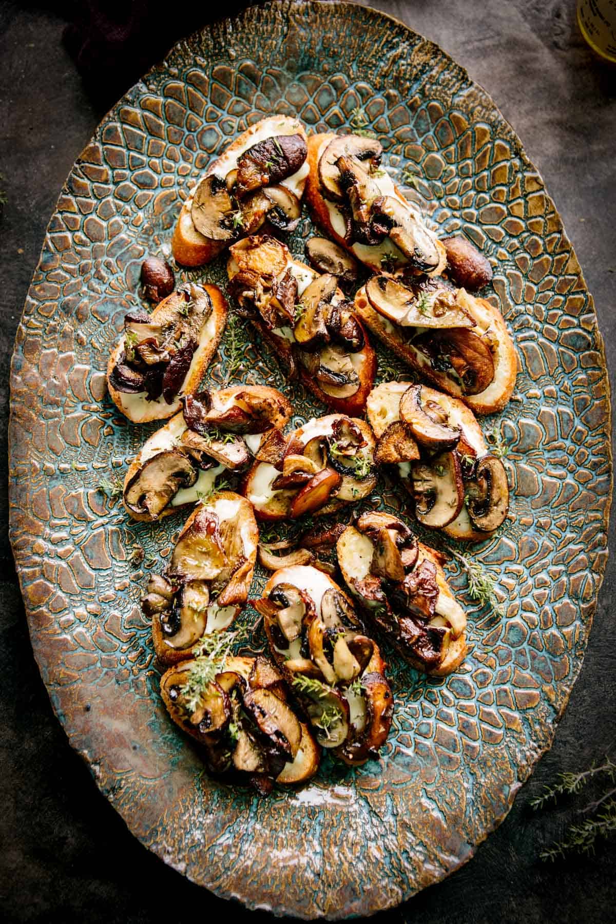 A platter of crostini topped with goat cheese and wild mushrooms.