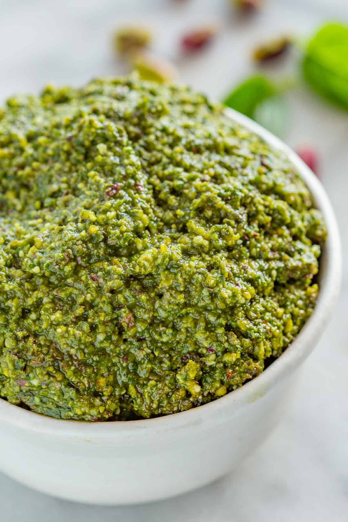 A white bowl of pistachio pesto.