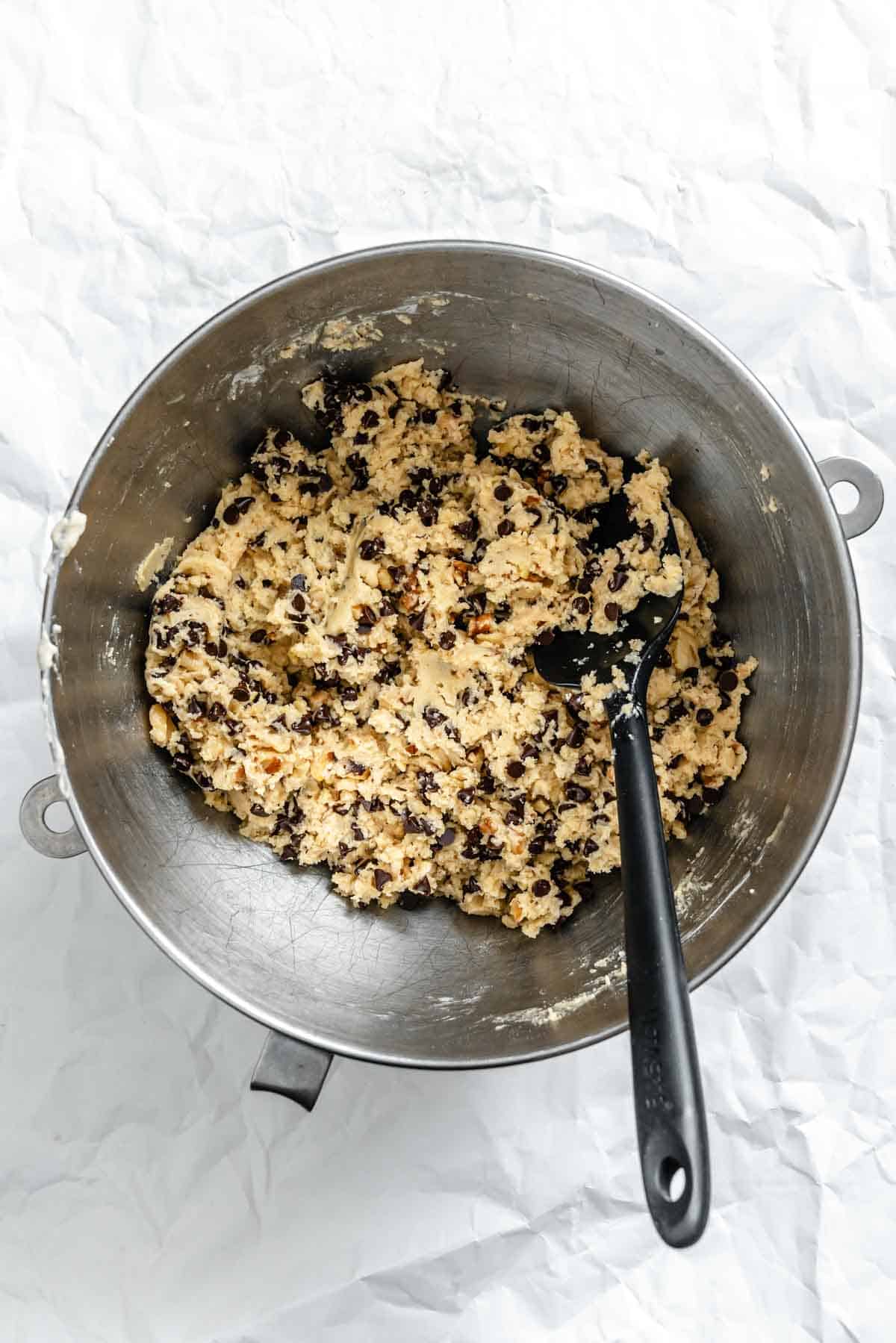 Completed cookie dough in a mixing bowl showing a smooth, thick texture with chocolate chips incorporated.