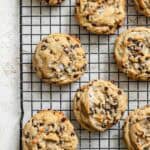 Close-up of baked chocolate chip cookies cooling on a wire rack.