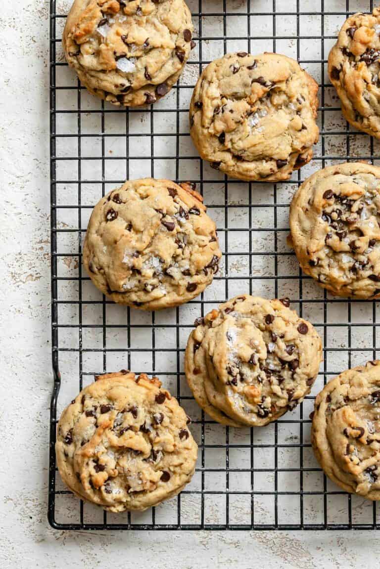 Close-up of baked chocolate chip cookies cooling on a wire rack.