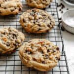 Multiple chocolate chip cookies arranged on a cooling rack, showing their texture and chocolate chunks.
