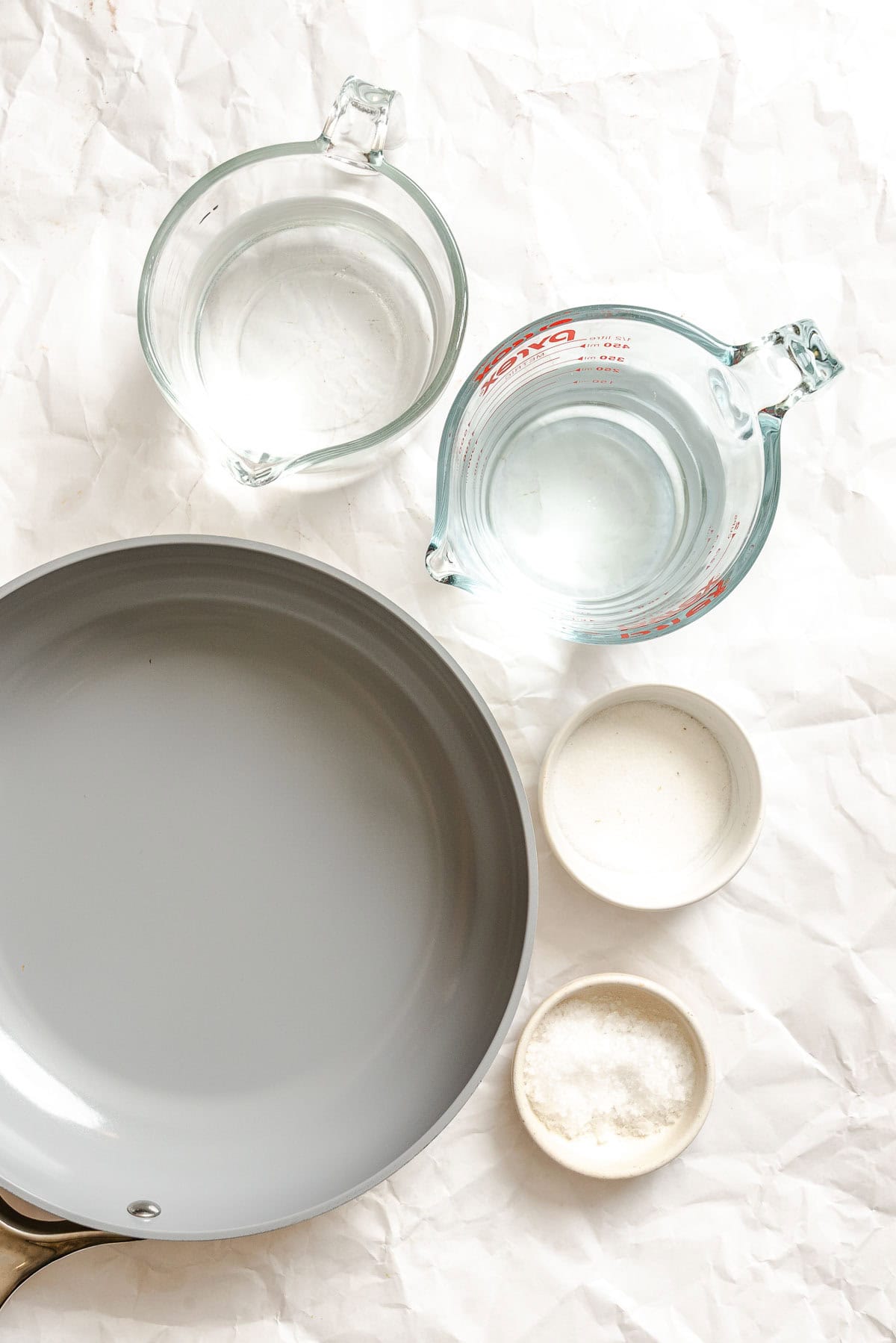 Vinegar, water, sugar, and salt next to a saucepan, ready for making the pickling brine.
