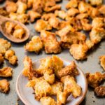 Plate of crunchy, golden brown croutons with more spread out across the pan.