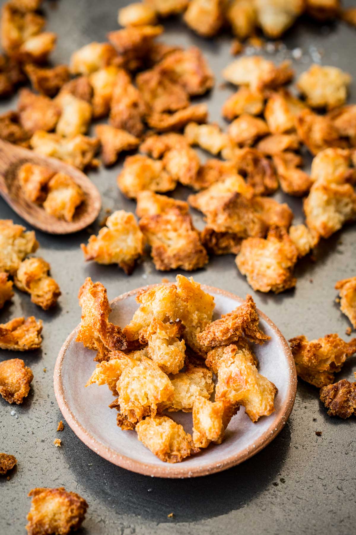 Plate of crunchy, golden brown croutons with more spread out across the pan.