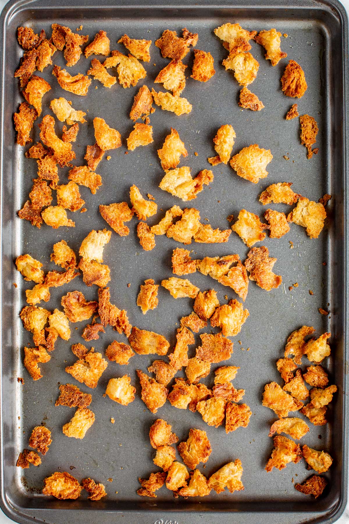 Golden, crisp croutons just out of the oven on a sheet pan.