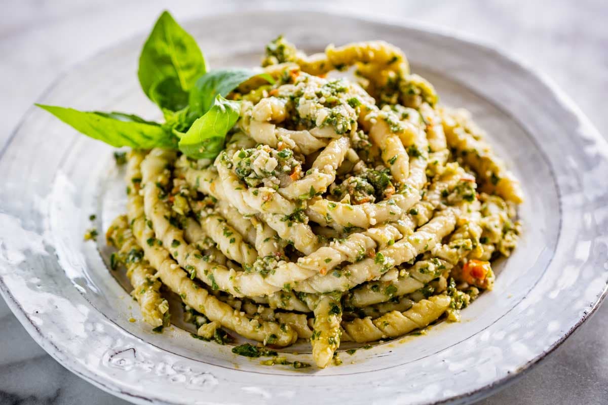 Twisted pasta with Sicilian pesto alla Trapanese served on a rustic white plate.