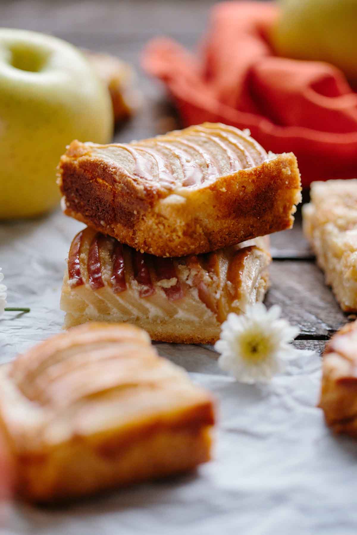 Close-up of stacked apple almond shortbread bars showing the buttery shortbread crust and layered sweet apple filling with thin apple slices on top.