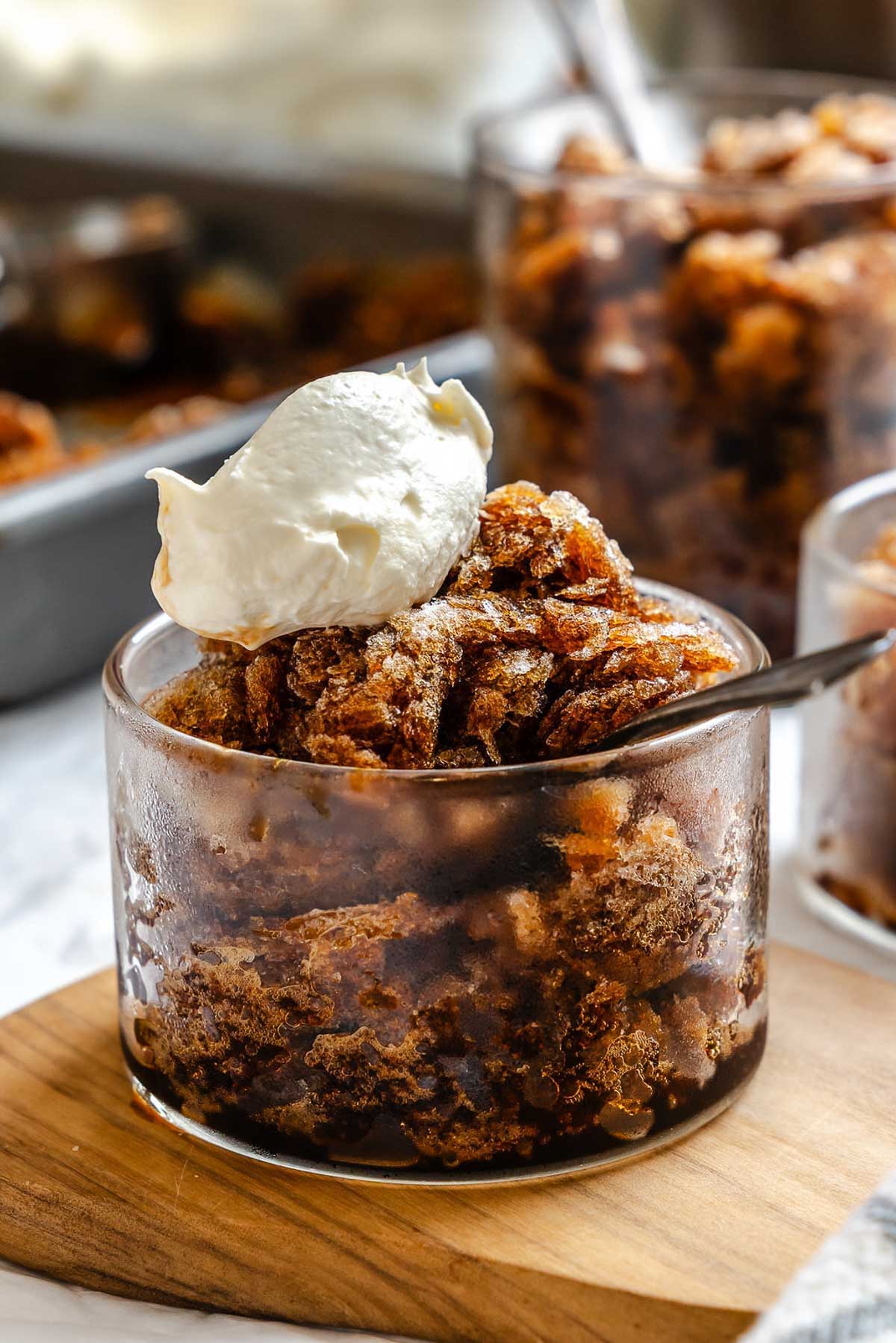 Glass dish of coffee granita topped with a dollop of whipped cream.