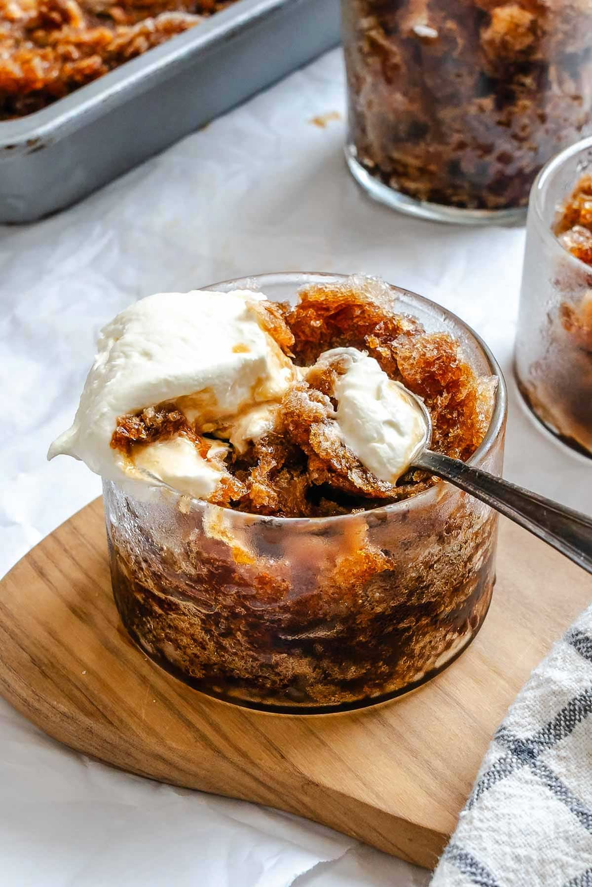 Close-up of a spoonful of granita and whipped cream scooped from a glass.