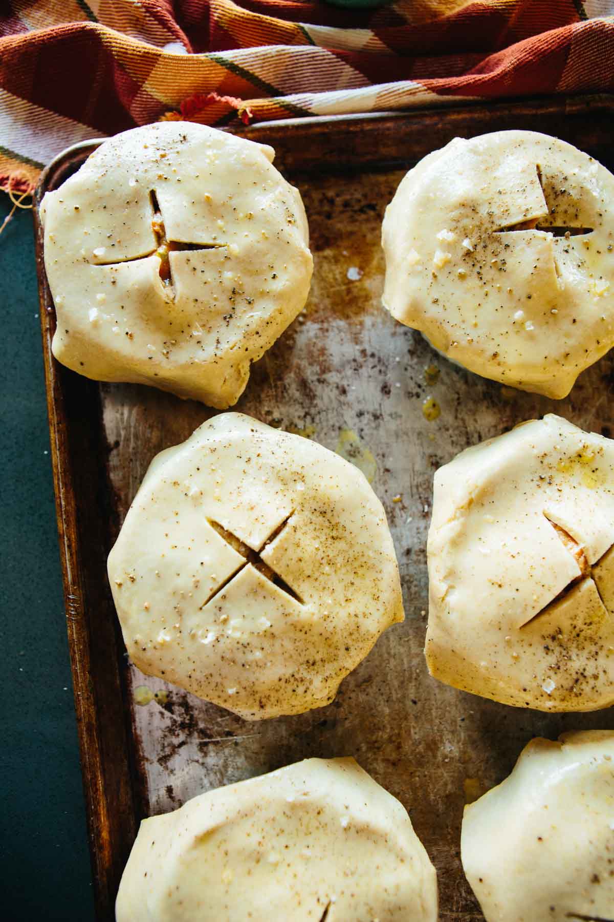 Ramekins topped with unbaked pie crust, scored with an