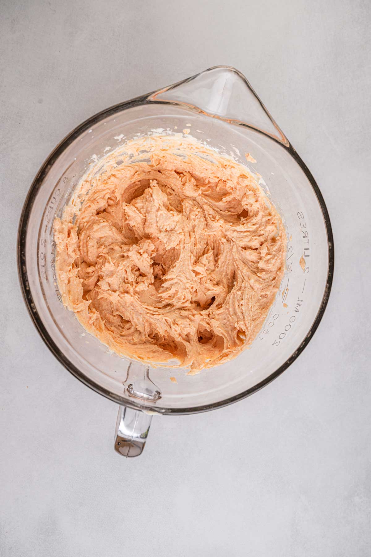 Pumpkin cannoli filling mixture whipped until creamy and smooth in a glass mixing bowl.