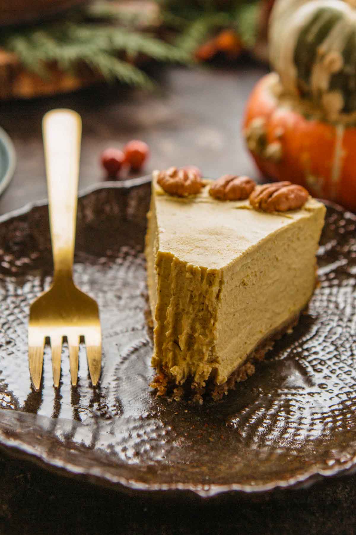 Close-up of a partially eaten slice of vegan pumpkin cheesecake revealing its smooth, creamy interior.