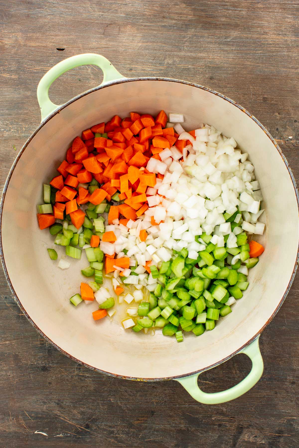 Diced carrots, celery and onions arranged in a large Dutch oven before cooking.