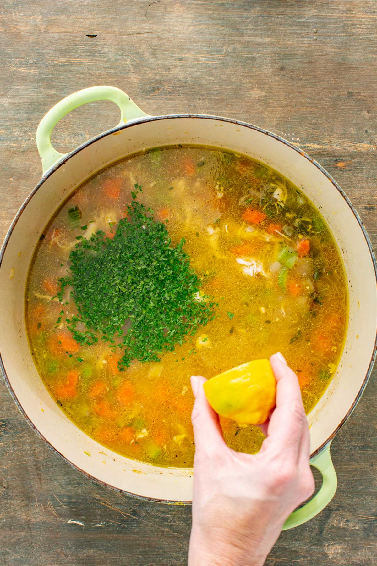 Finishing the soup with chopped parsley and a squeeze of lemon over the broth.