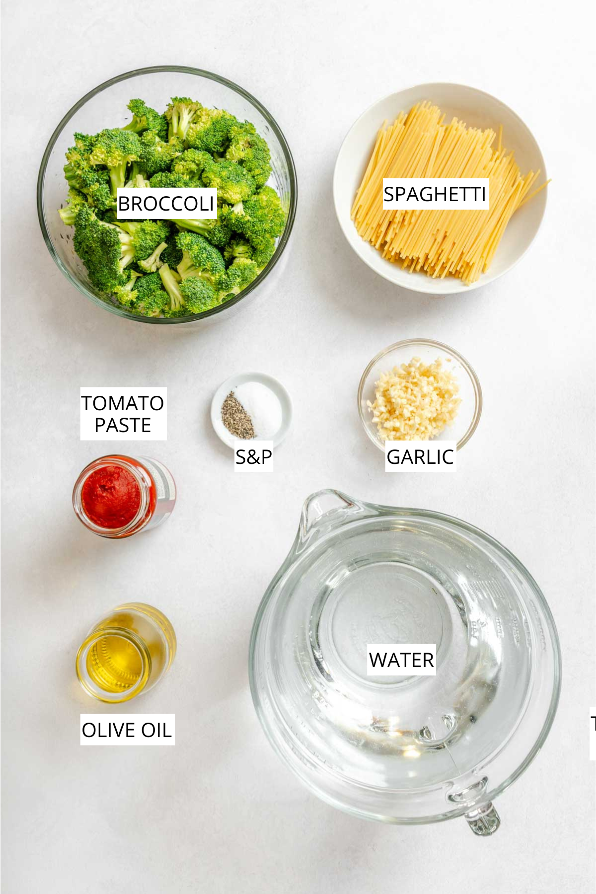 Fresh broccoli florets, dry spaghetti, minced garlic, tomato paste, olive oil, salt and black pepper, and water arranged on a light surface.